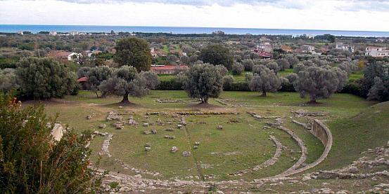 il teatro greco-romano di locri epizephiri, disposto scenograficamente lungo le pendici di una collina che digrada verso il mare di costa calabra in bicicletta.