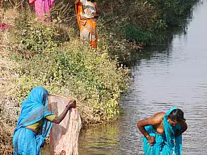 donne che si lavano in un fiume
