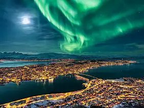 aurora borealis dancing over the city of tromso and full moon, northern norway
