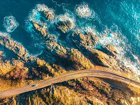 aerial view of road, rocky sea shore with waves and stones at sunset in lofoten islands,...