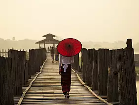 rear view of woman with traditional umbrella on u bein bridge