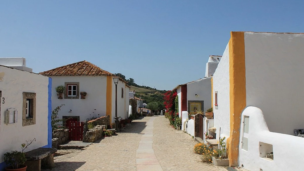 il piccolo villaggio bianco alle porte di lisbona: mura candide e case colorate per un paradiso dove il tempo si ferma