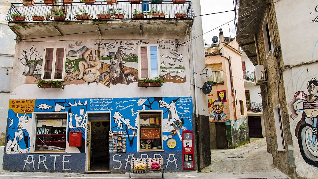 dal 1969 è il primo borgo dei murales in italia, e oggi ce ne sono 150 che raccontano l'incredibile storia di questo paesino