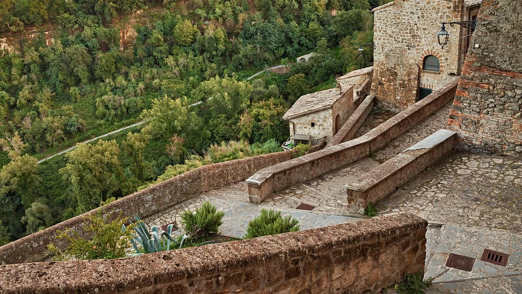 lazio, il borgo medievale della tuscia che domina la valle dei calanchi tra torri e calanchi argillosi