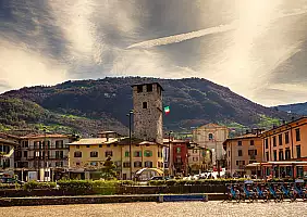 turistipercaso Square of the town of Pisogne with the bell tower and the mountain behind.