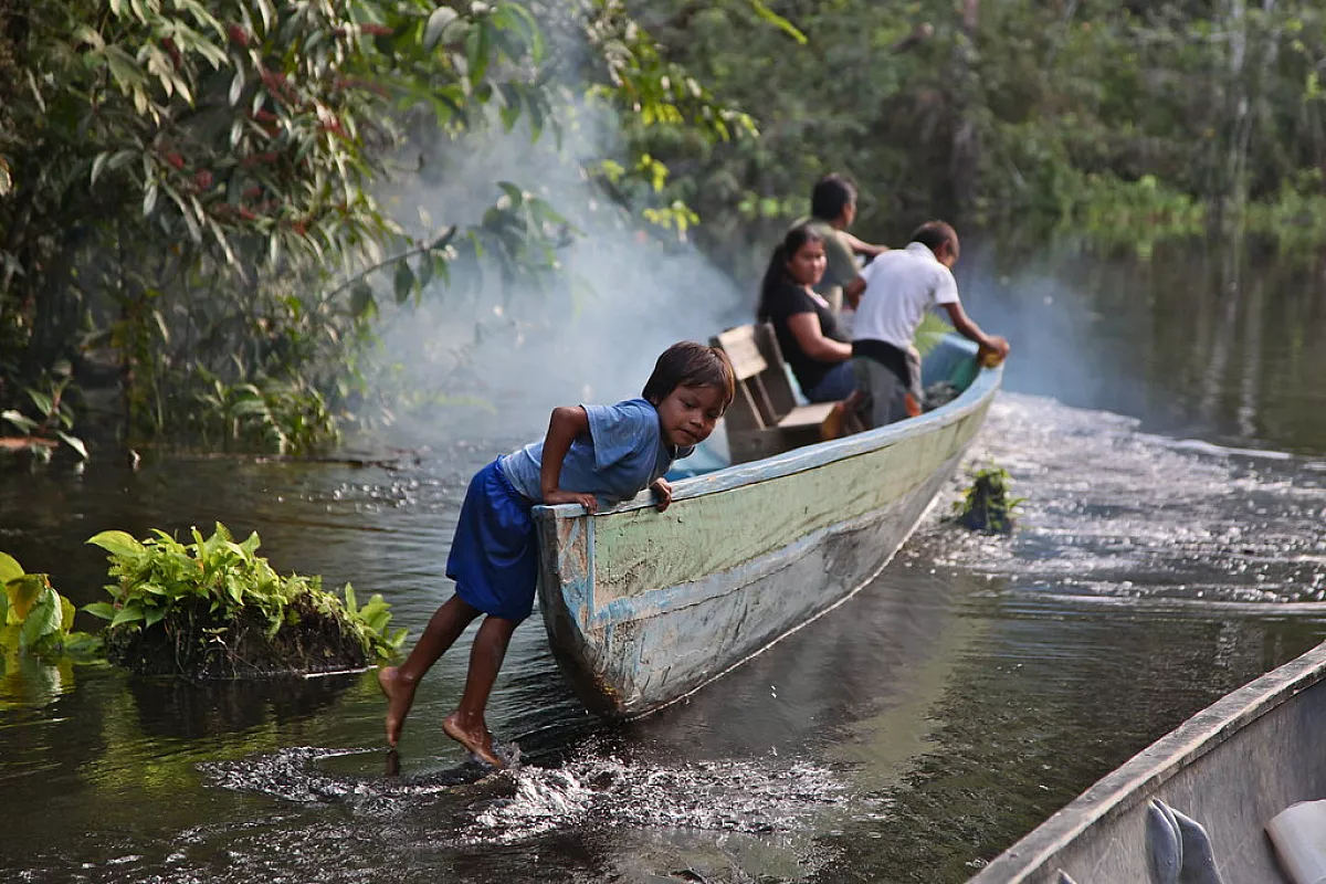 una famiglia Quechua sale su una barca su un rio della Foresta Amazzonica