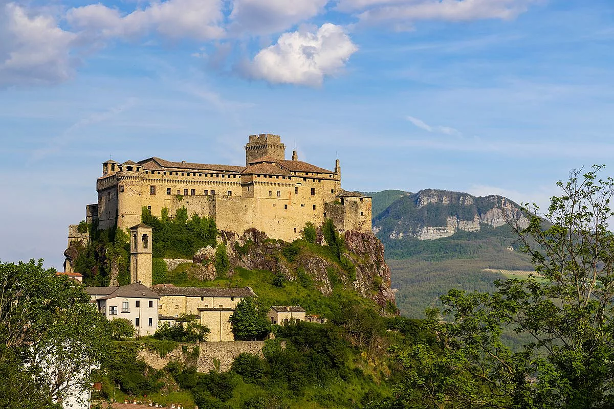 Una fortezza gigantesca aggrappata alla roccia e la leggenda di un fantasma che attraversa i secoli